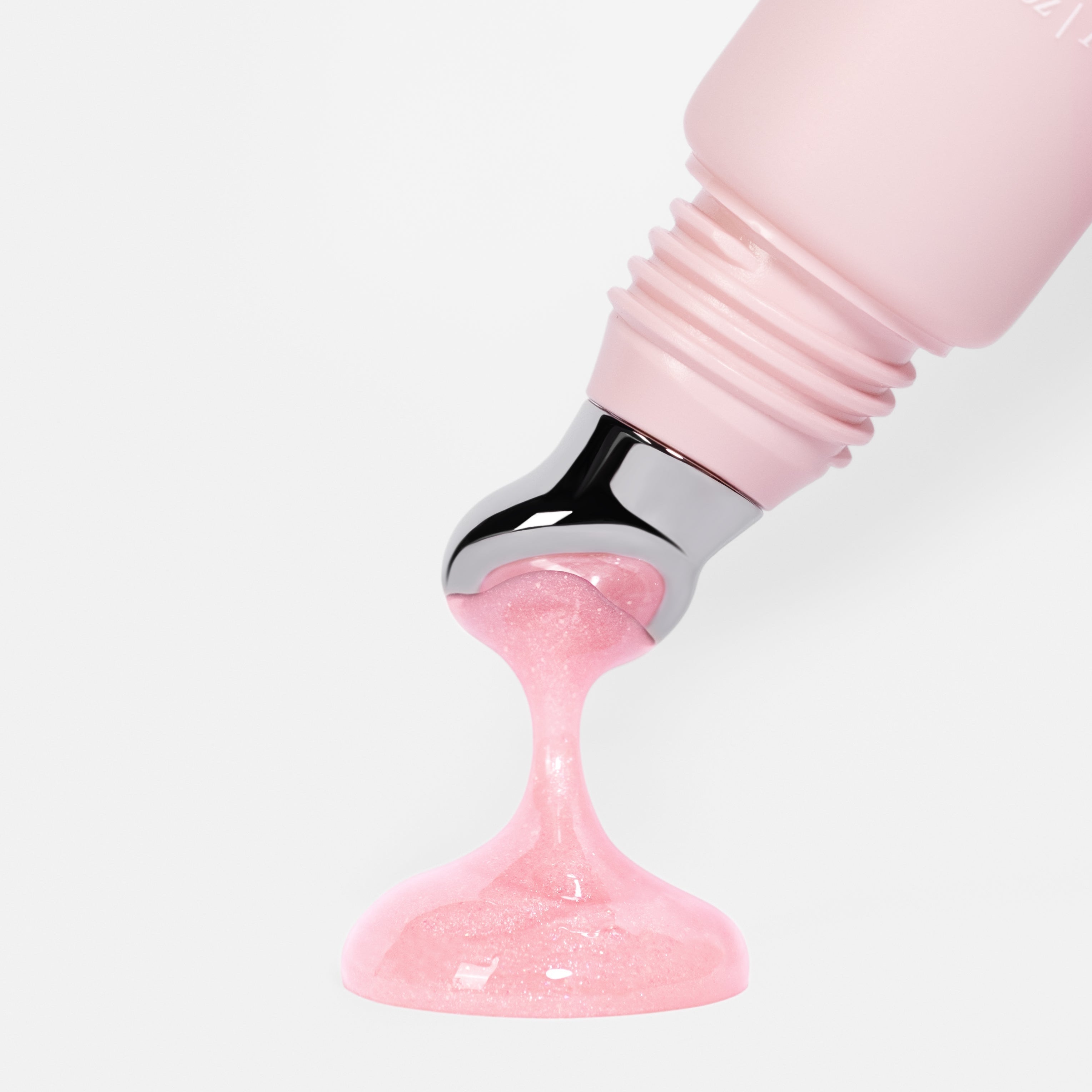 a sheer, baby pink sparkle lip treatment to deeply hydrate and plump up your lips being squeezed out of an-gloss tube